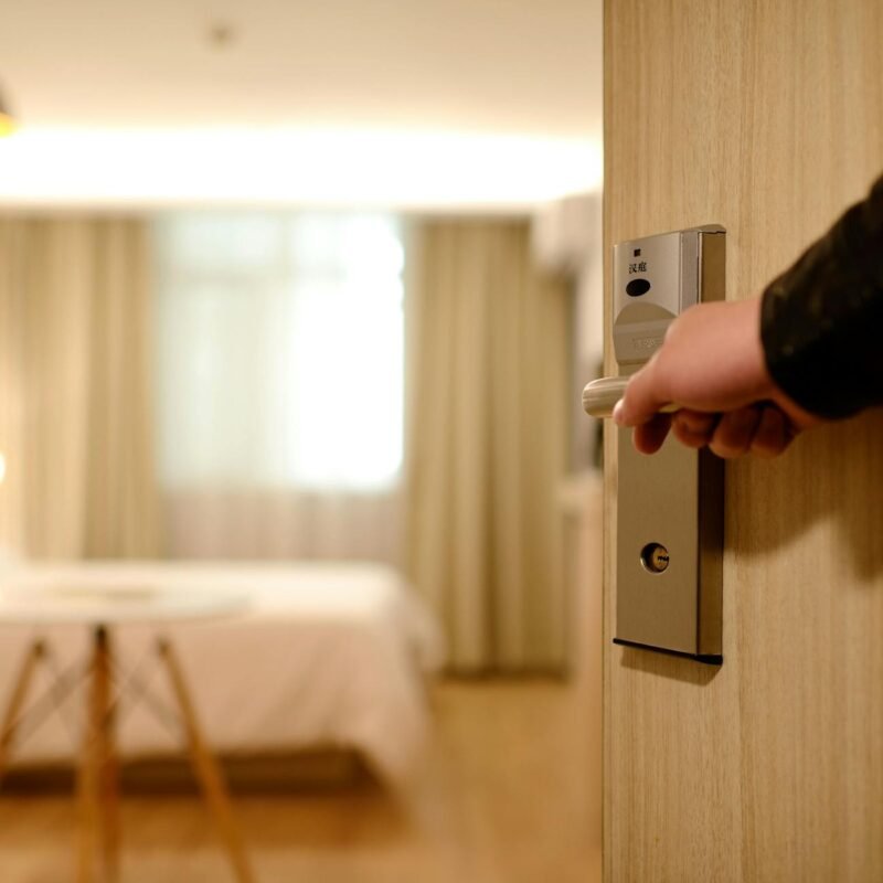 person holding on door lever inside room